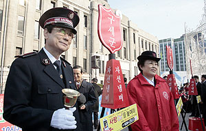 				▲이날 모인 1백여 명의 구세군 전광표 사령관과 유성자 여성사업부 총재가 시종행사에서 타종하고 있다. ⓒ고준호 기자				