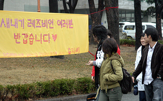 				▲새학기를 맞아 캠퍼스를 찾은 학생들이 재미있는 듯한 표정으로 플래카드를 보고 있다. ⓒ 송경호 기자				