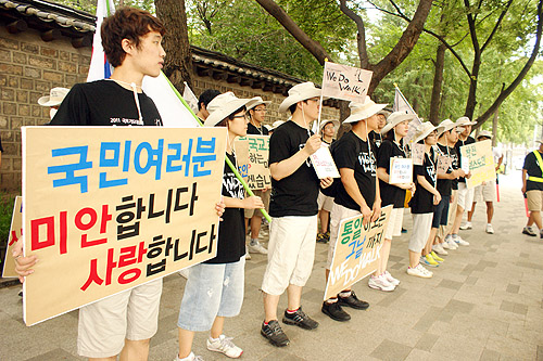 ▲서울을 걷던 청년들이 덕수궁 돌담길에서 지나가는 시민들을 향해 피켓을 들어보이고 있다. ⓒ위두웍 제공