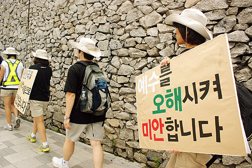 ▲청년들이 국민들을 향해 &lsquo;예수를 오해시켜 미안합니다&rsquo;라는 메시지를 들고 걷고 있다. ⓒ위두웍 제공